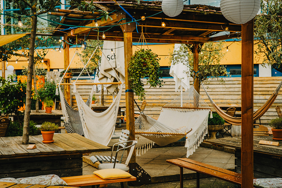 GEmütliche Terrasse des Hallo Emil mit verschiedenen Sitzmöglichkeiten und Hängematten