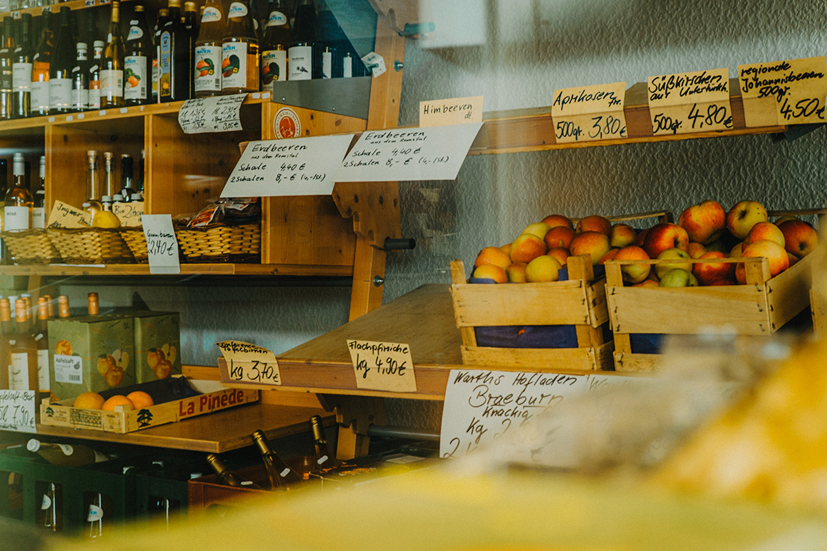 Warenregal mit Obstkisten und Wein im Warths Hofladen