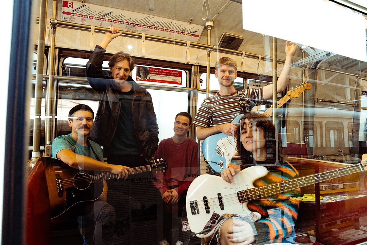 Die Stuttgarter Sängerin JISKA wird mit ihrer Band in eienr Bahn sitzend durch die Scheibe fotografiert